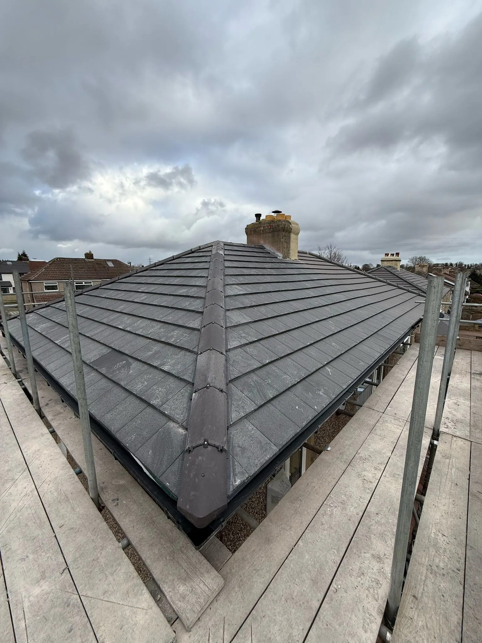 Finished slate-effect tile hip roof with new ridge