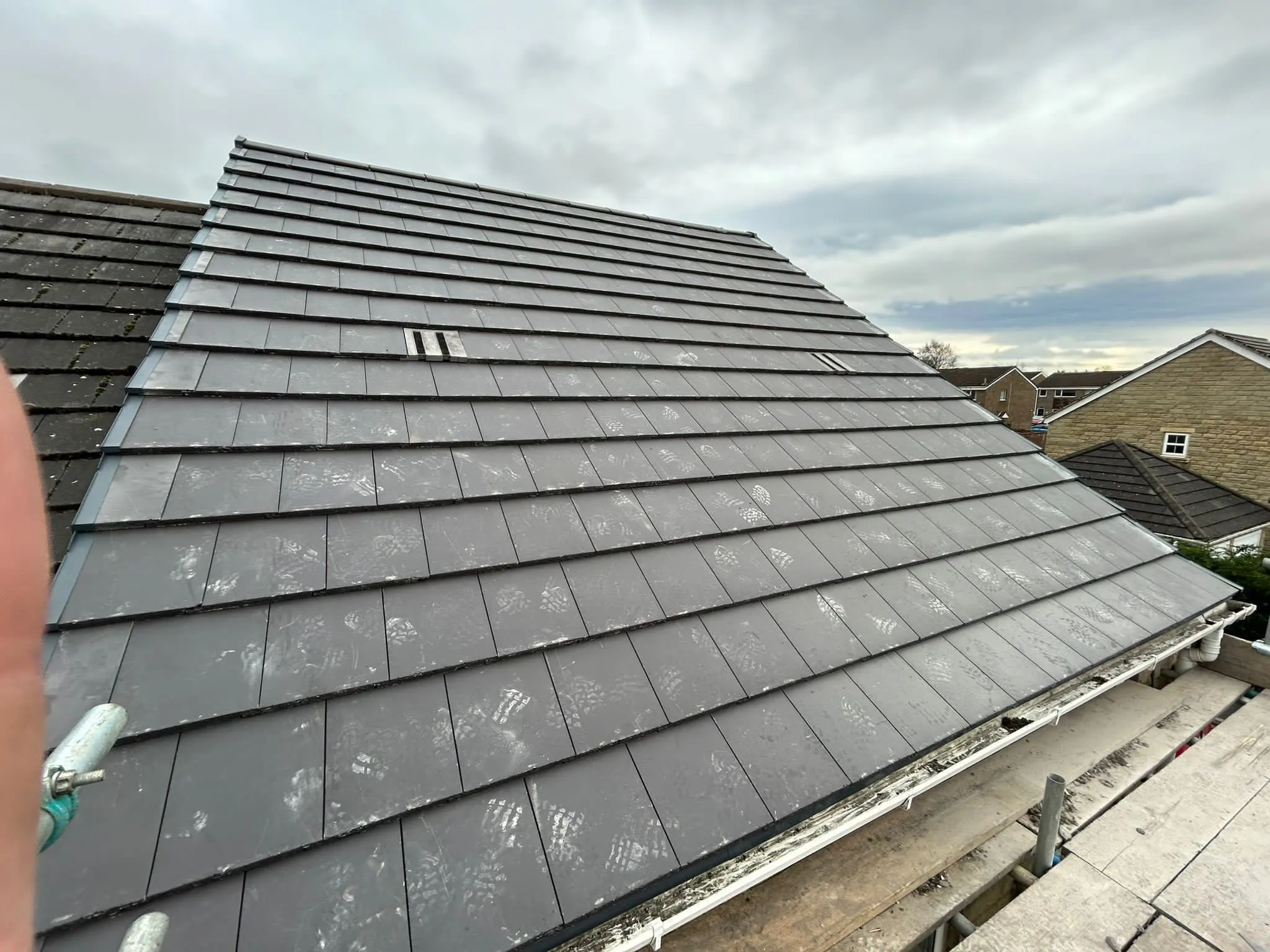 Slate-effect tiles being laid on a roof